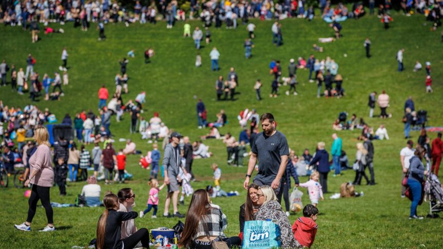 Image of people enjoying their day on a grassy hill