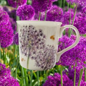 A white ceramic mug with pink flowers in the background.