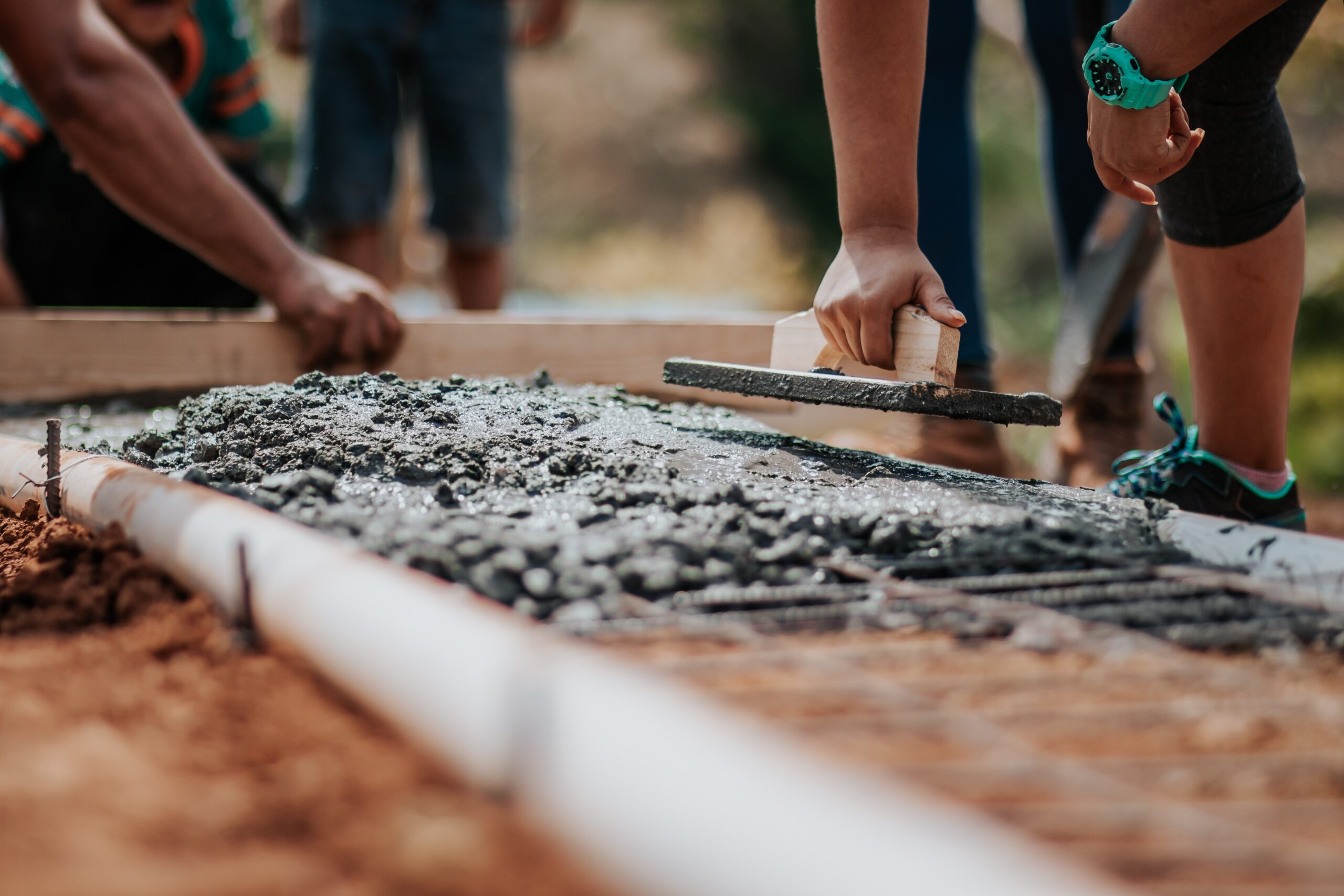 Workers laying some concrete for stonework.