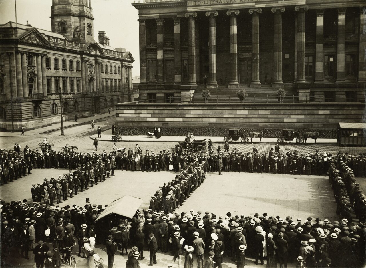 A black and white photo of soldiers in square formations outside the Harris.