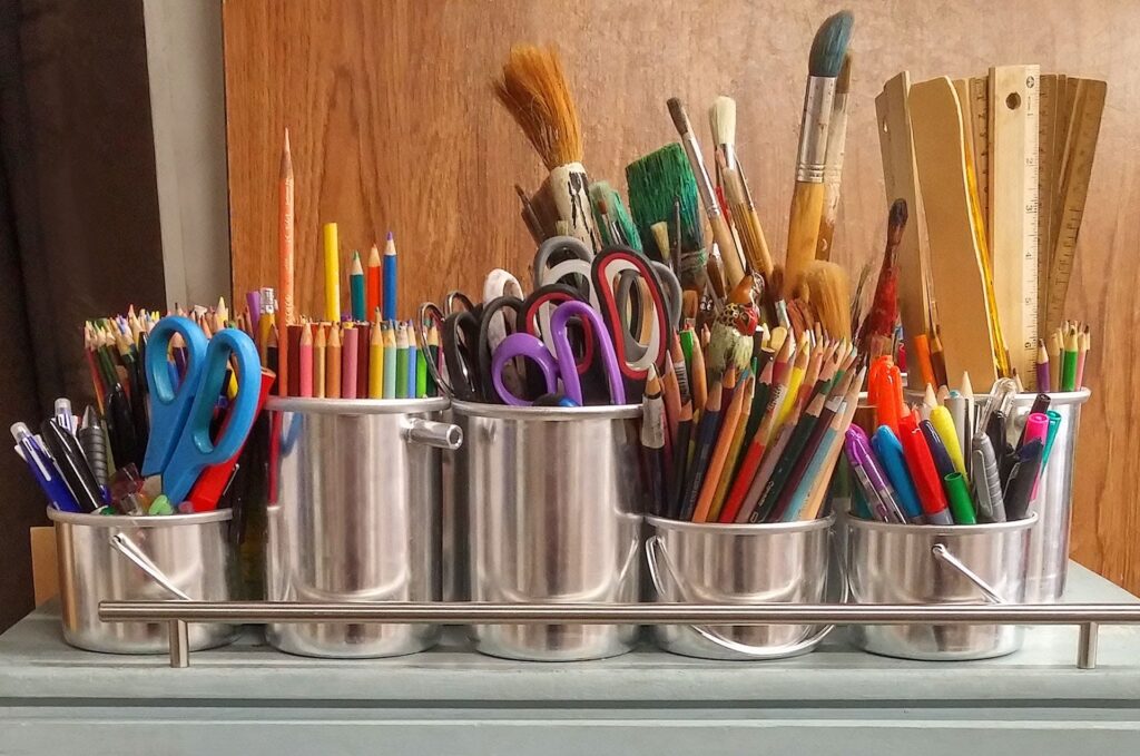 Image of scissors and pencils in silver pots.