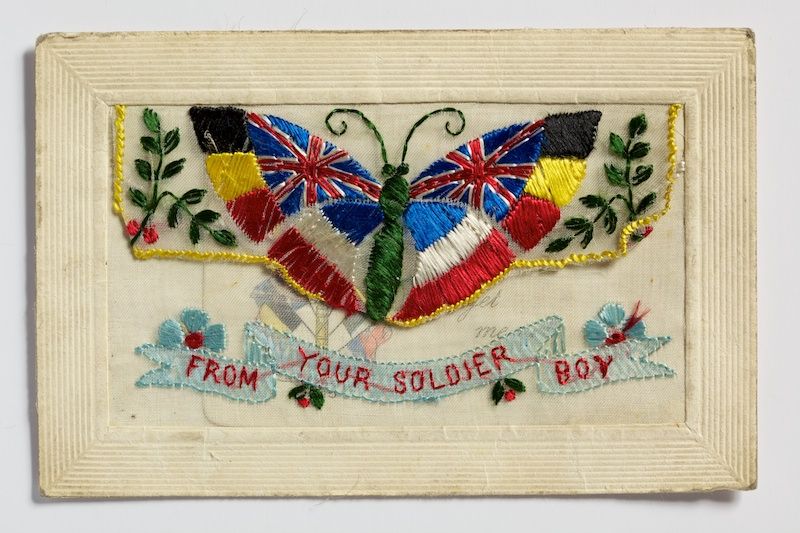 A postcard featuring a colourful embroidered butterfly.