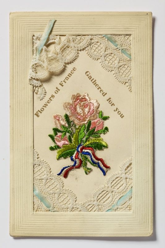 A postcard featuring embroidered flowers.