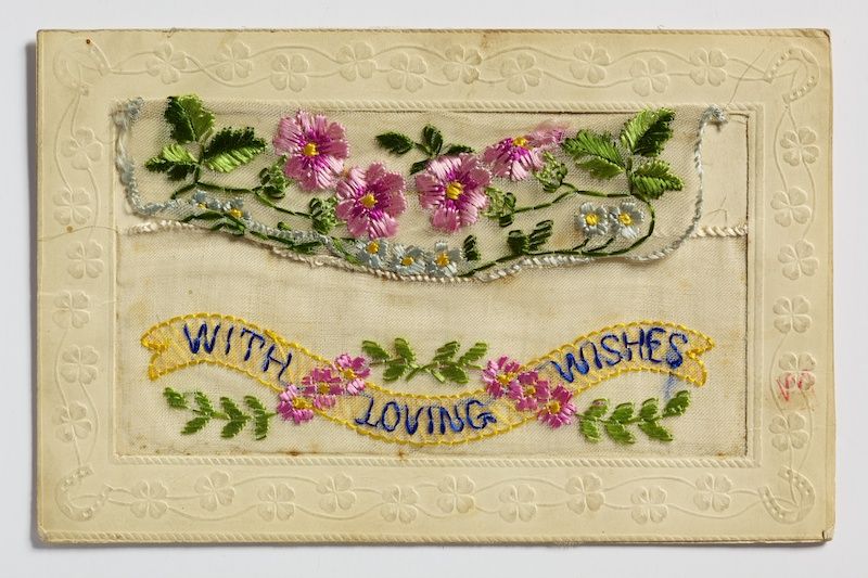 A postcard featuring colourful embroidery.