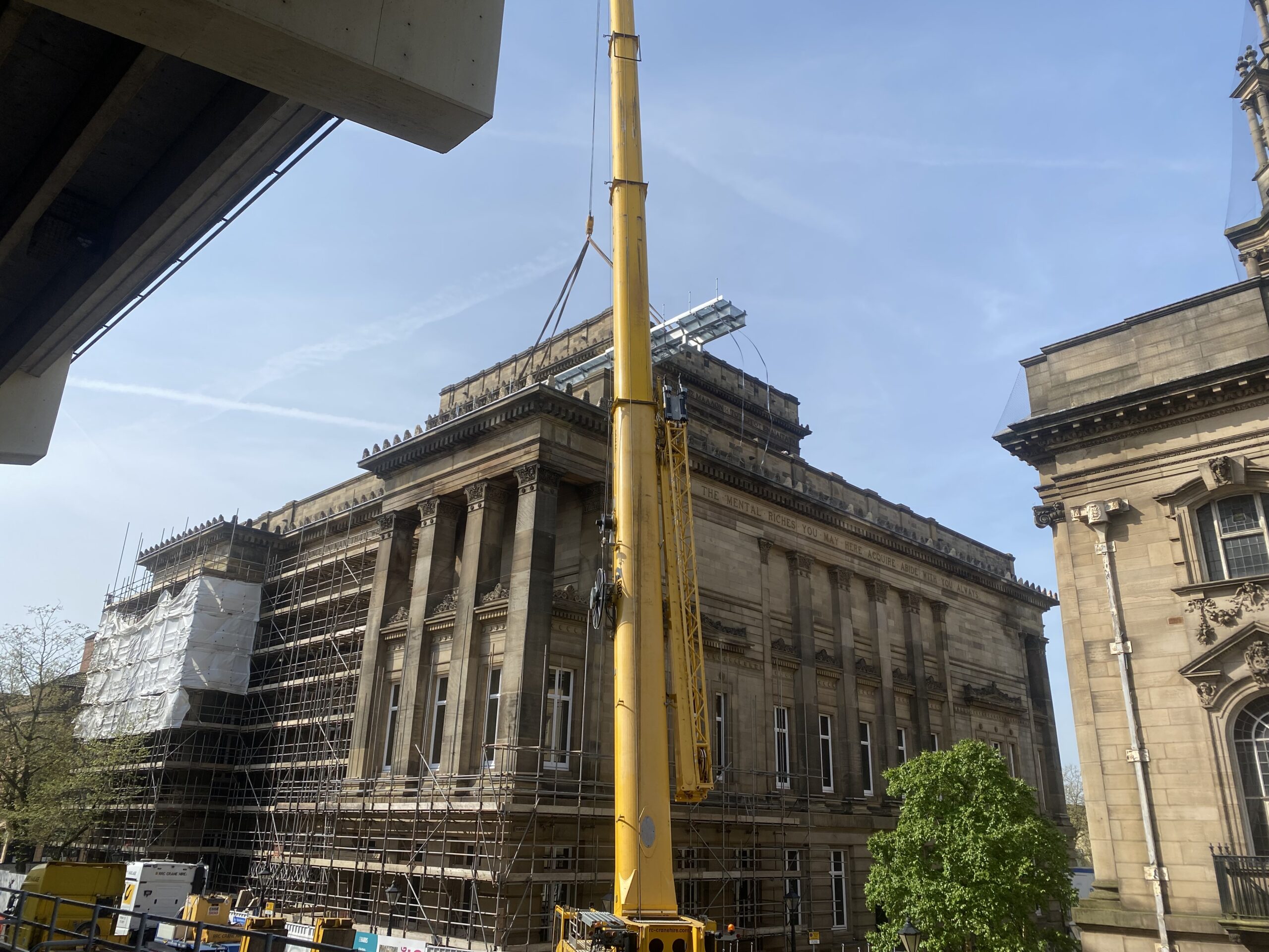 Image of a large yellow crane above The Harris building