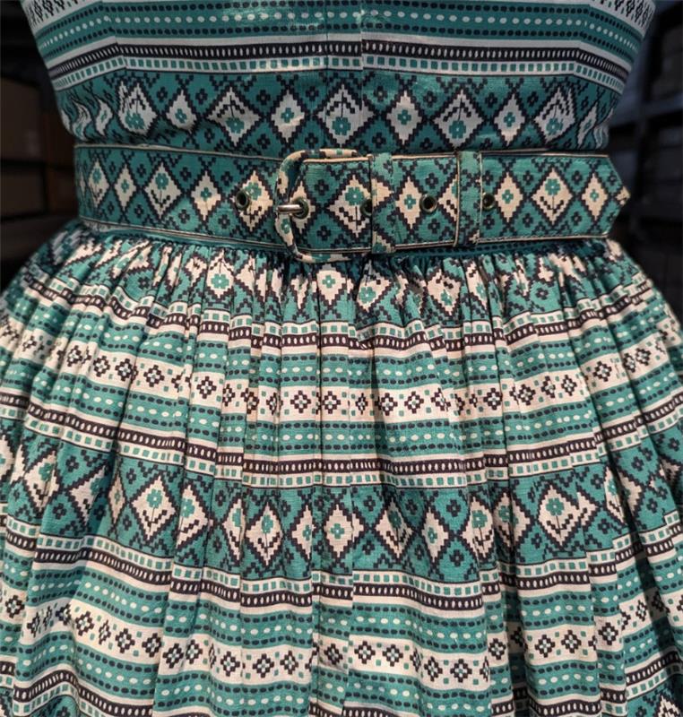 A close up of a green and white geometric patterned dress.