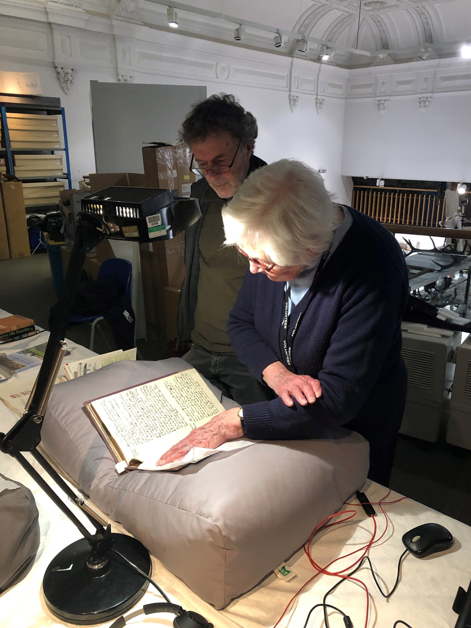 Two people study a text from the Harris' collection.