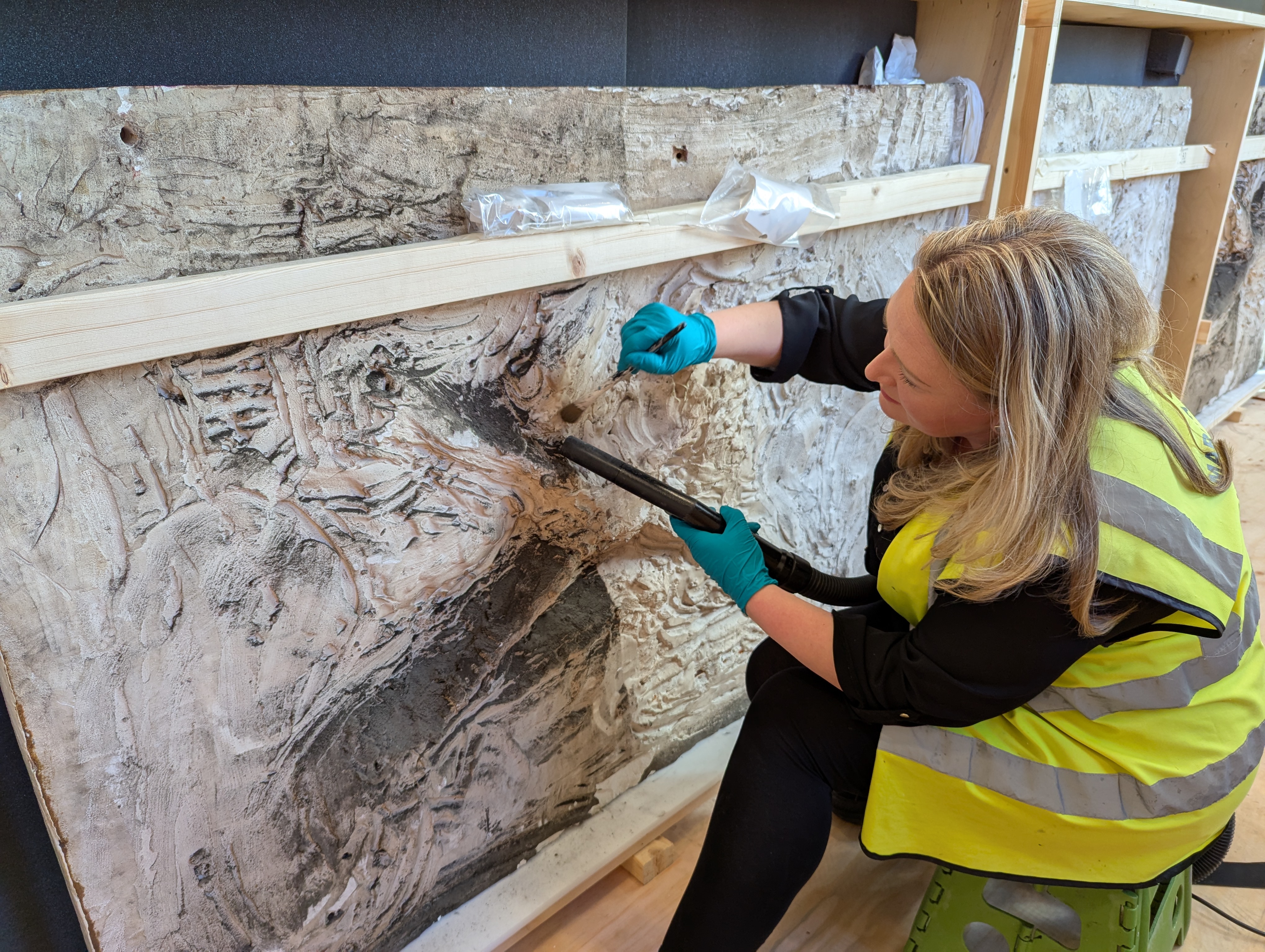 Image of a conservation specialist holding a brush on stone