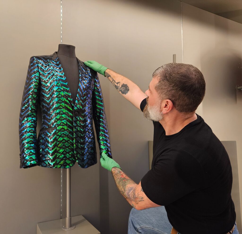 Image of a curator and a green sequined jacket.