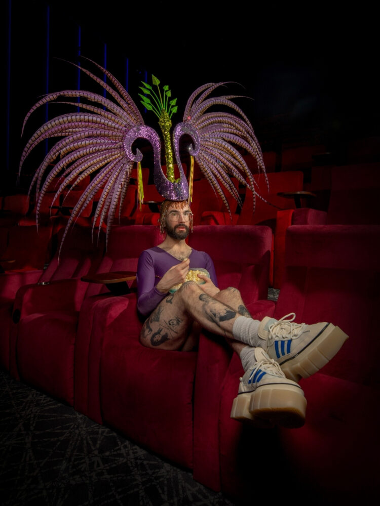 A person wearing a large headdress in the cinema.