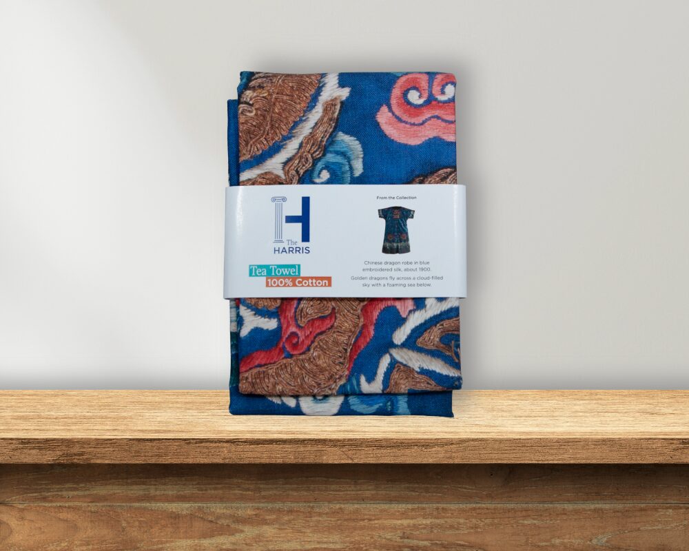 A blue tea towel featuring a dragon pattern.