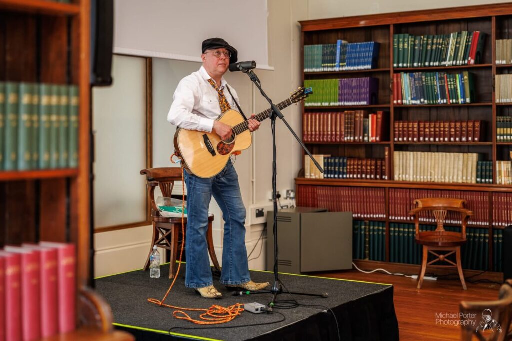 Image of a man playing a guitar.