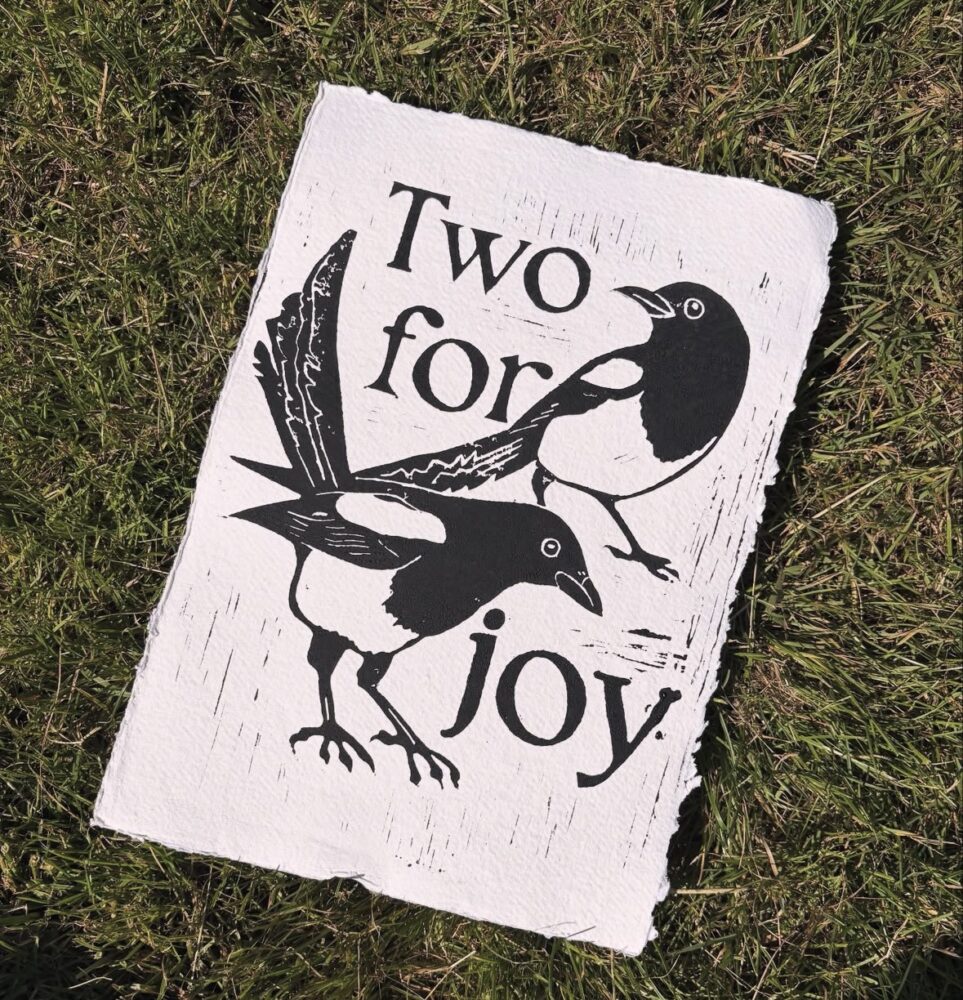 Black and white illustration of two magpies alongside the words "Two for joy," conveying a sense of happiness and positivity.