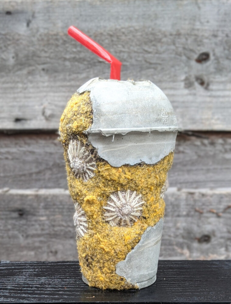 Image of a repurposed plastic cup with a red straw.