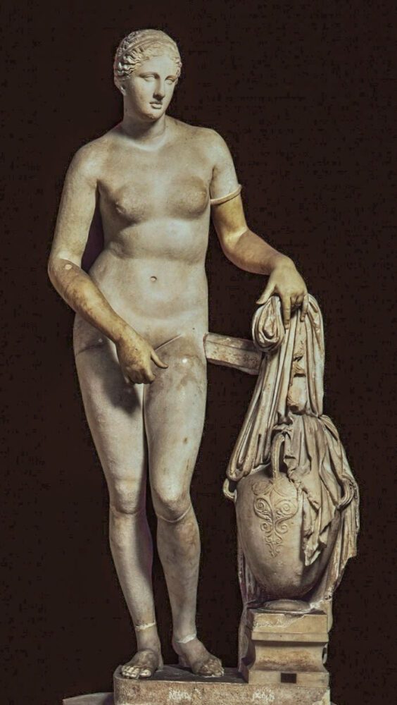 Ancient Greek marble statue of Aphrodite stands nude, her right hand modestly covering herself. Her left arm rests on a draped amphora, conveying grace and beauty.