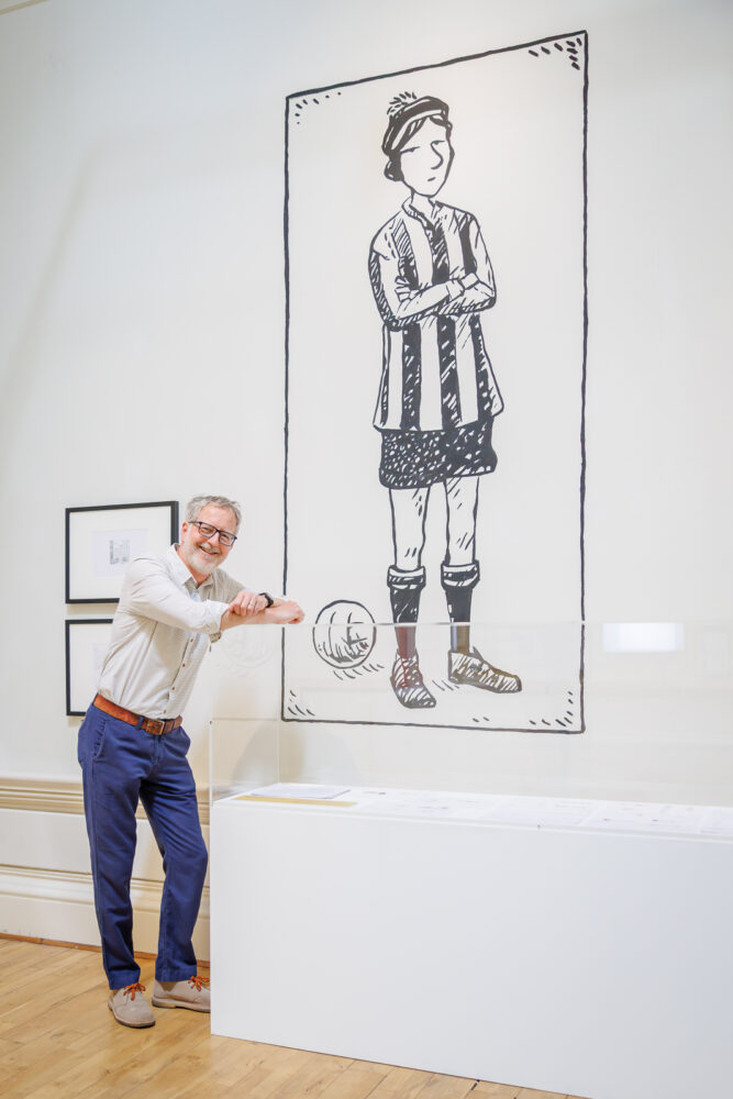 Image of a person with their arms crossed next to a large illustration of a female footballer.