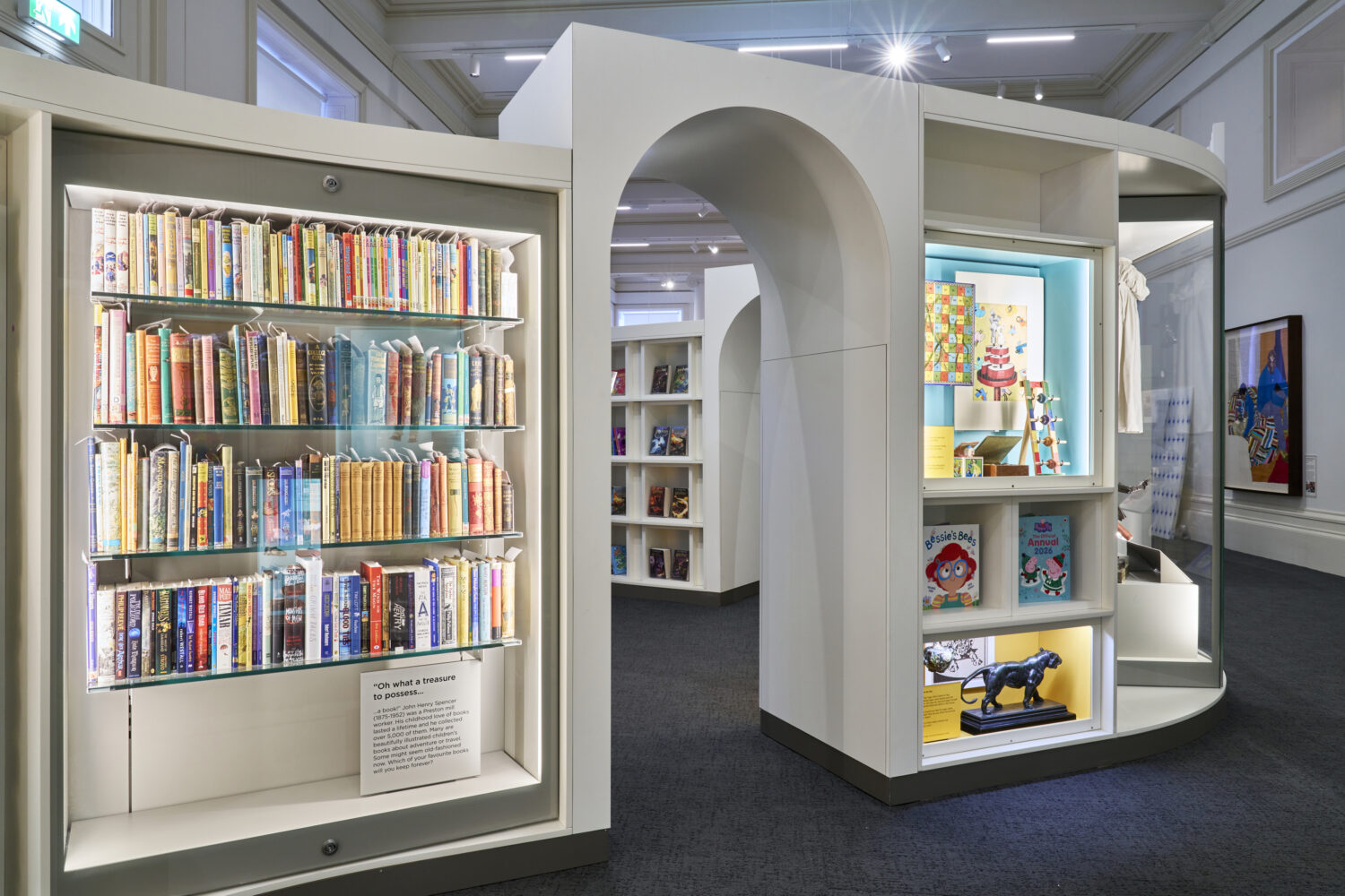 Modern library interior showcasing colorful book displays on well-lit shelves with a decorative archway. Bright, inviting atmosphere.