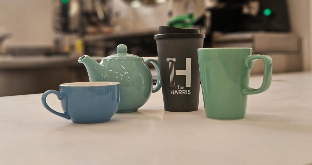 A teapot, tea cup, travel mug and green mug.