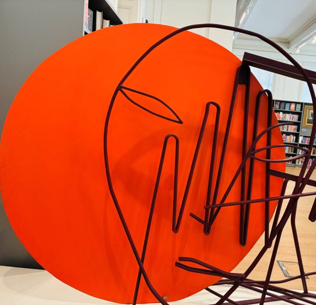 Bright orange and red artistic sculpture of a face.