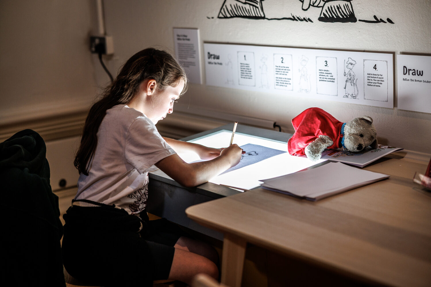 Image of a young person sketching ona lightbox.