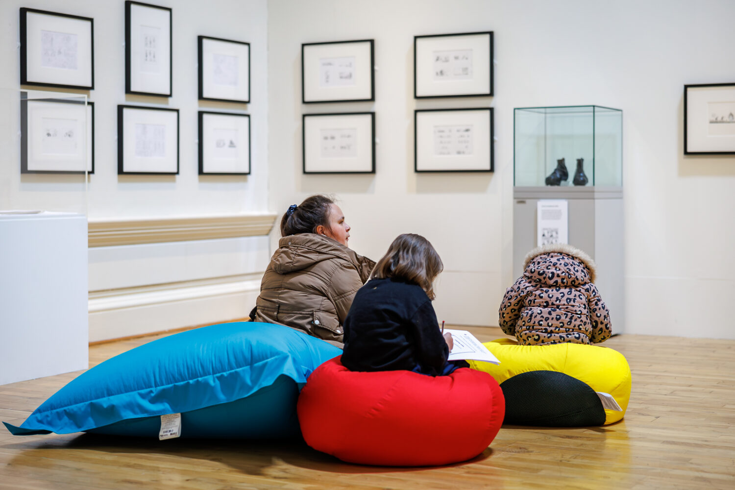 Three visitors sat on red, yellow and blue beanbags