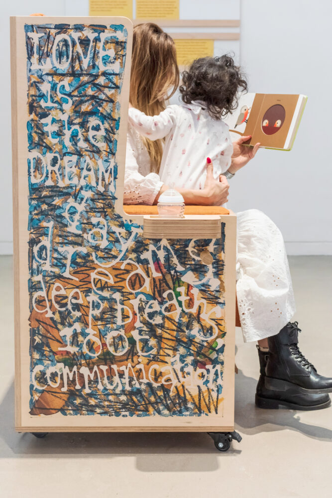 Large artwork on a wooden chair with writing ' Love is The Dream'