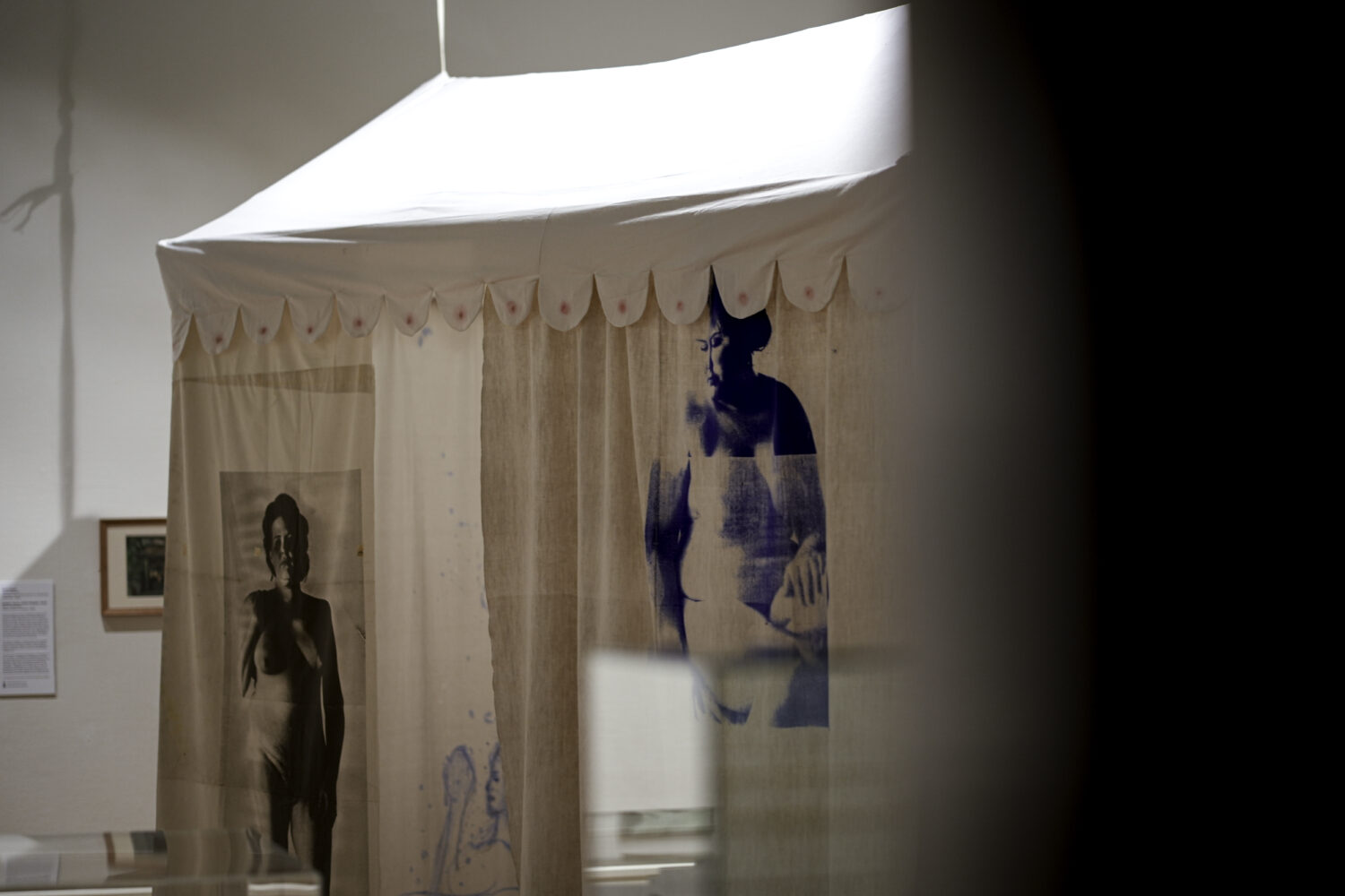 Image of an artwork featuring a white tent with blue a screenprinted image of a woman.