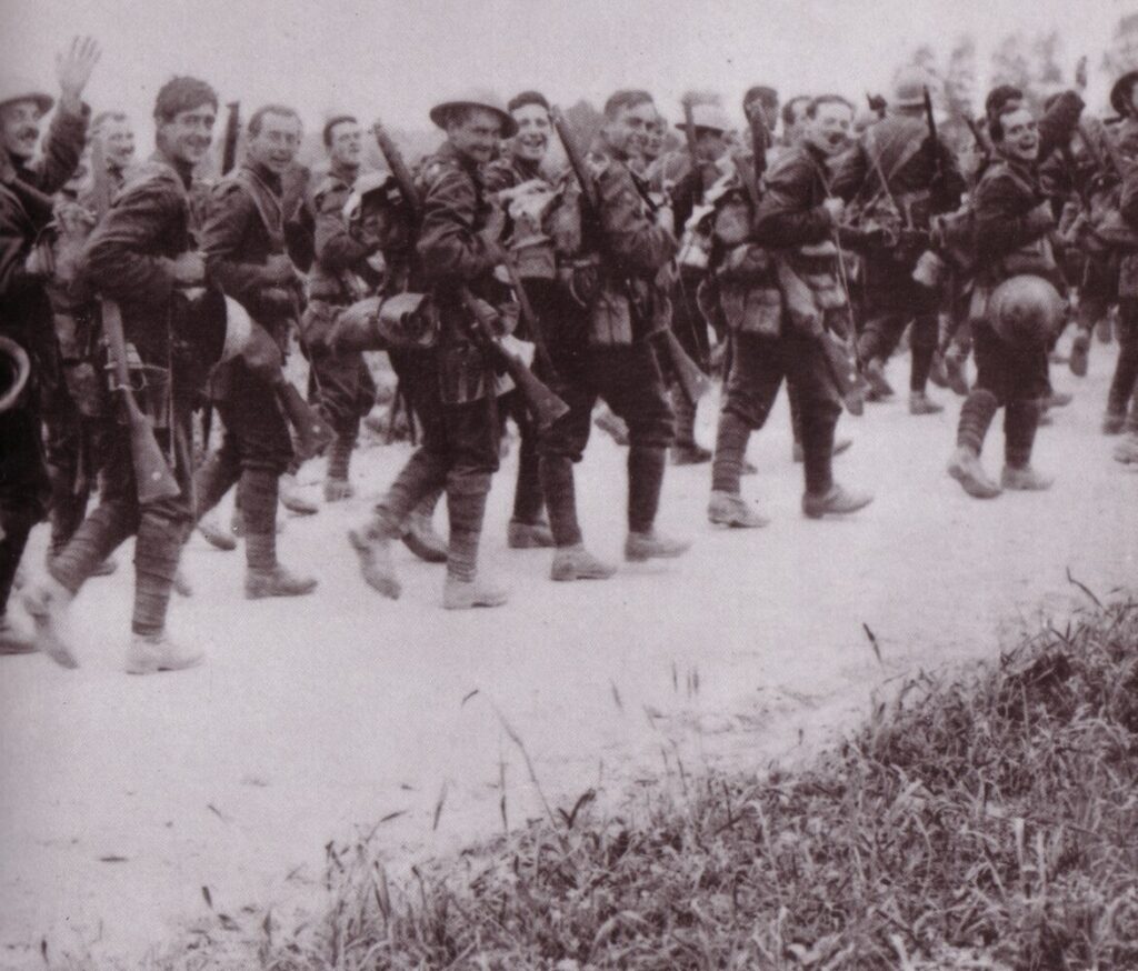 Image of soldiers from 1916, wearing uniforms and walking in a line.