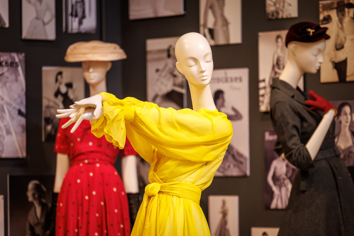 Image of three mannequins wearing bright coloured dresses.